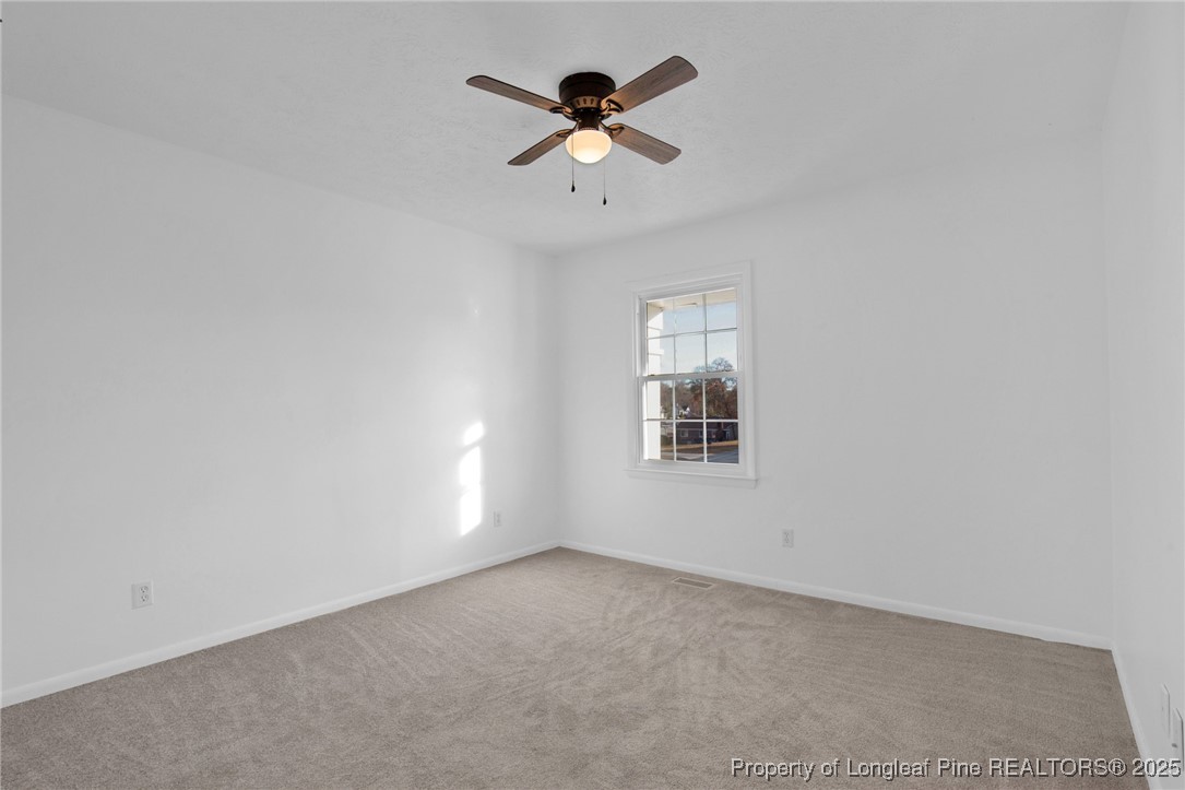 6806 Beaver Stone Road Fayetteville, NC 28314 - Photo 26 of 42 an empty room with ceiling fan and window