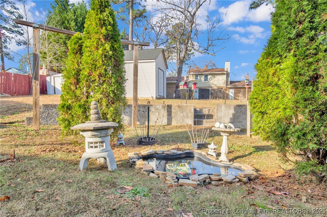 6806 Beaver Stone Road Fayetteville, NC 28314 - Photo 40 of 42 a view of a patio with table and chairs and potted plants