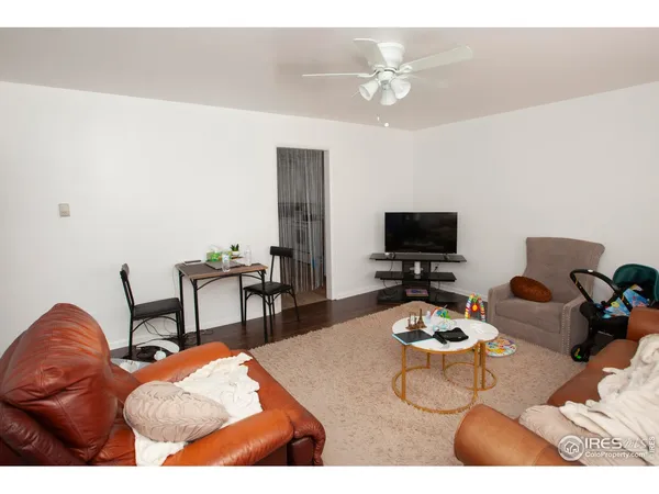 a living room with furniture a flat screen tv and kitchen view