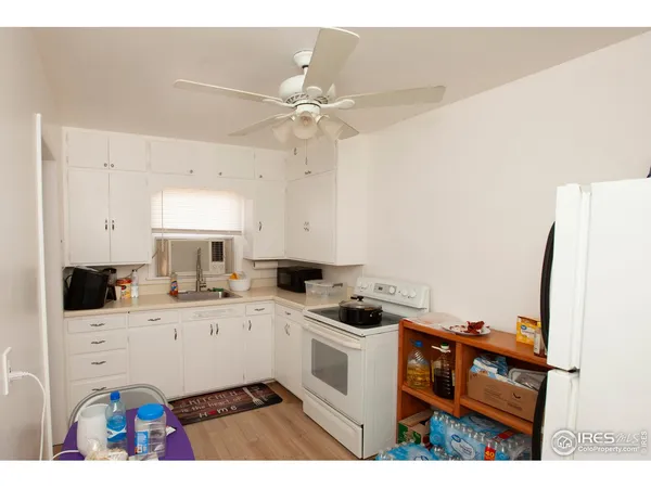 a kitchen that has a sink a stove and cabinets