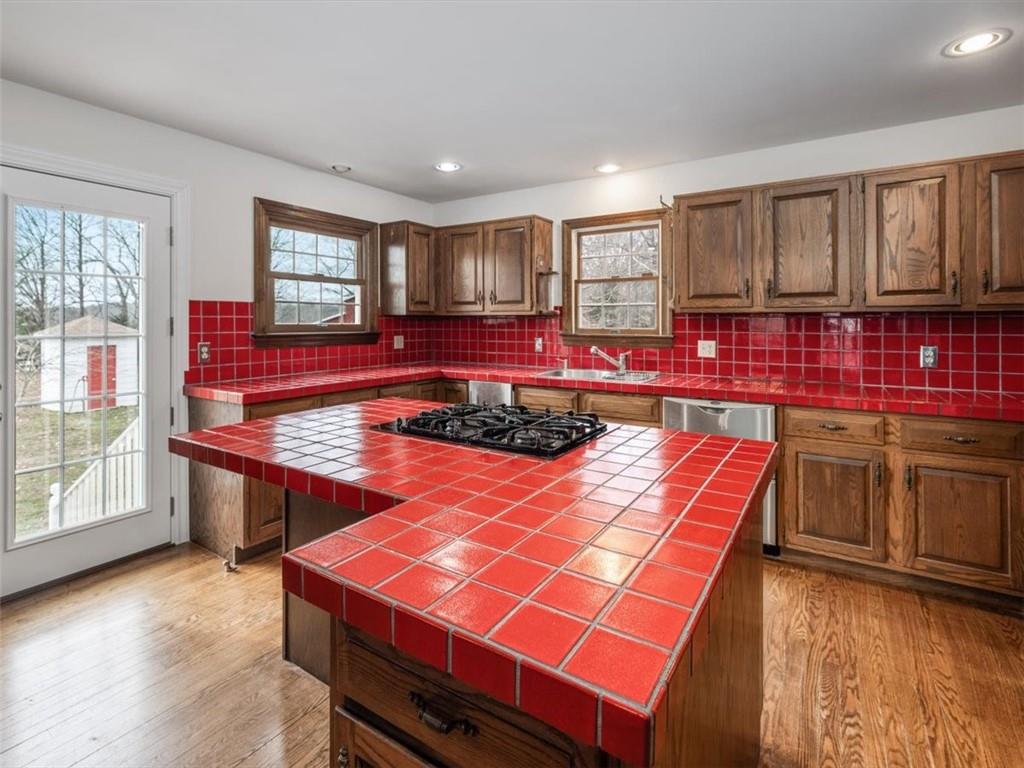 12831 Sturgeon Point Road Charles City, VA 23030 - Photo 11 of 31 The tiled kitchen island includes a gas cooktop, a short nreakfast bar and ample storage