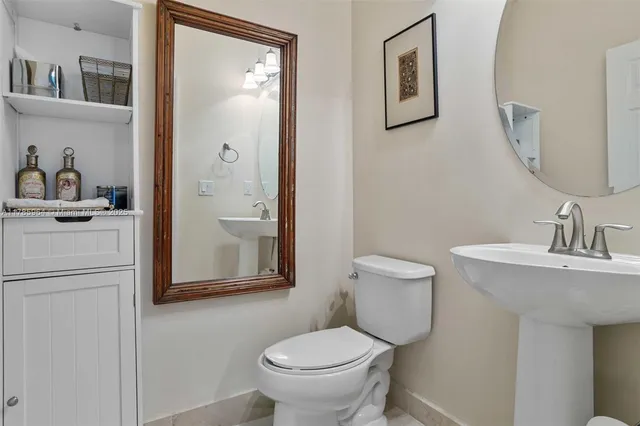 a bathroom with a toilet a sink and mirror