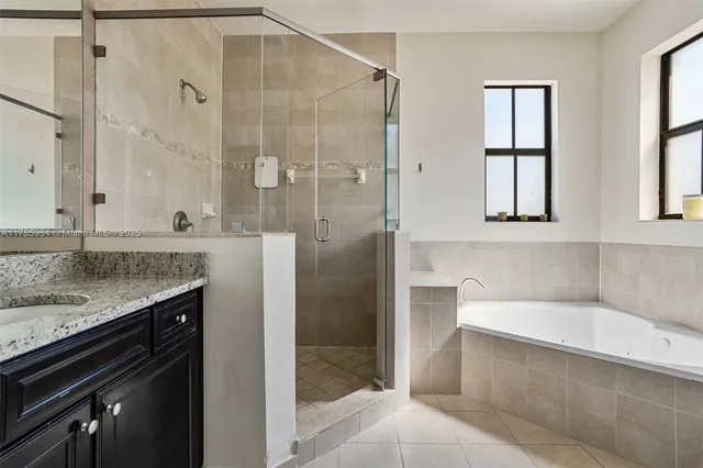 a bathroom with a granite countertop bathtub shower sink and mirror