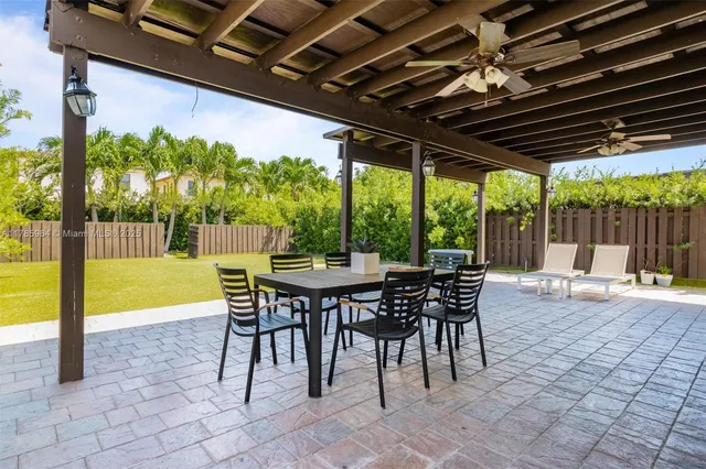 a view of a patio with a table chairs and a grill