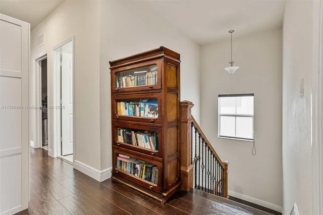 a view of a hallway with wooden floor and entryway
