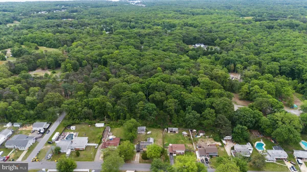 an aerial view of residential houses with outdoor space and trees
