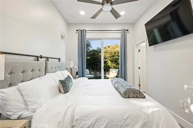a bedroom with a large bed and a flat screen tv