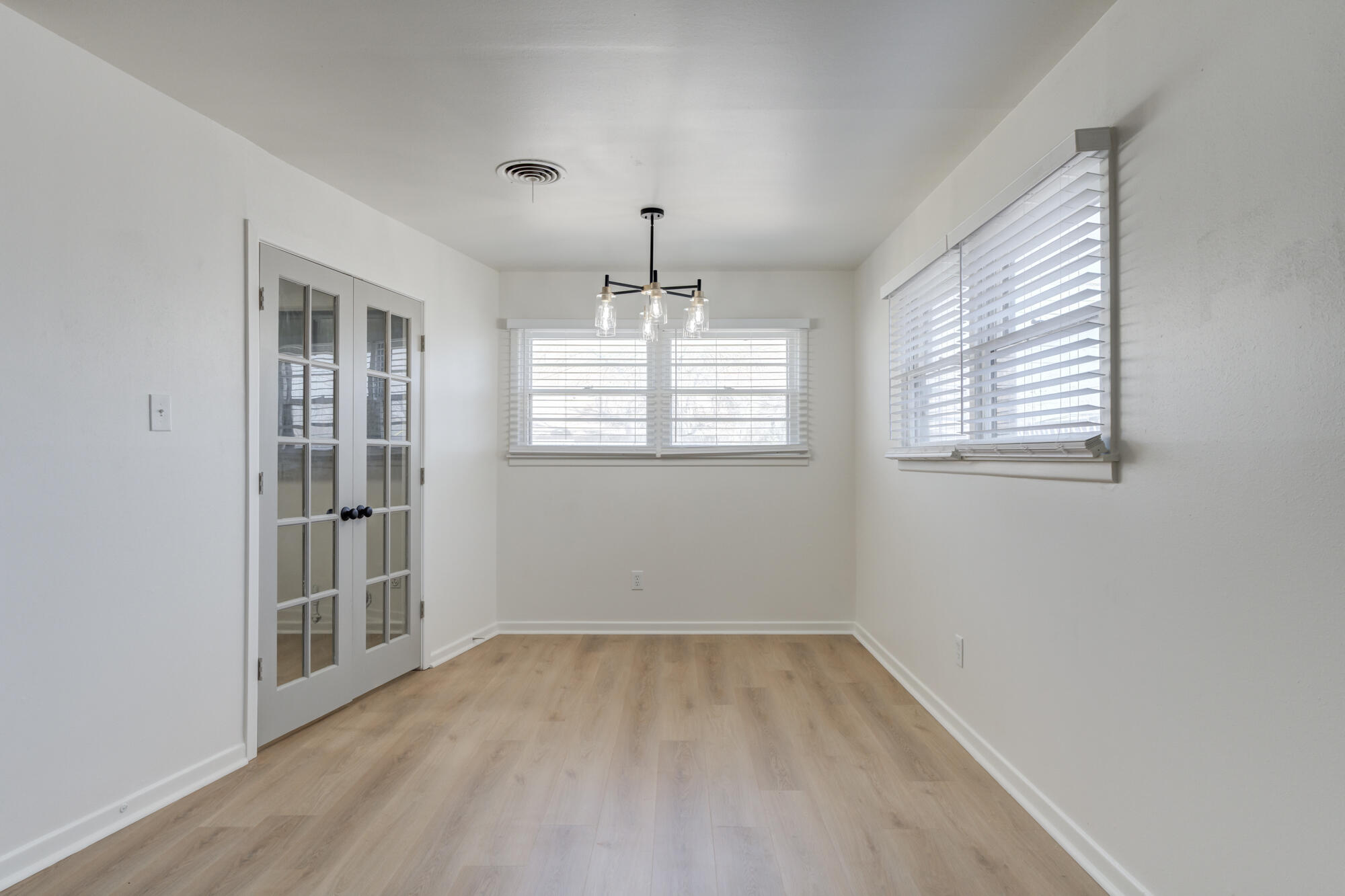 4404 28th Street Lubbock, TX 79410 - Photo 10 of 39 an empty room with windows and chandelier