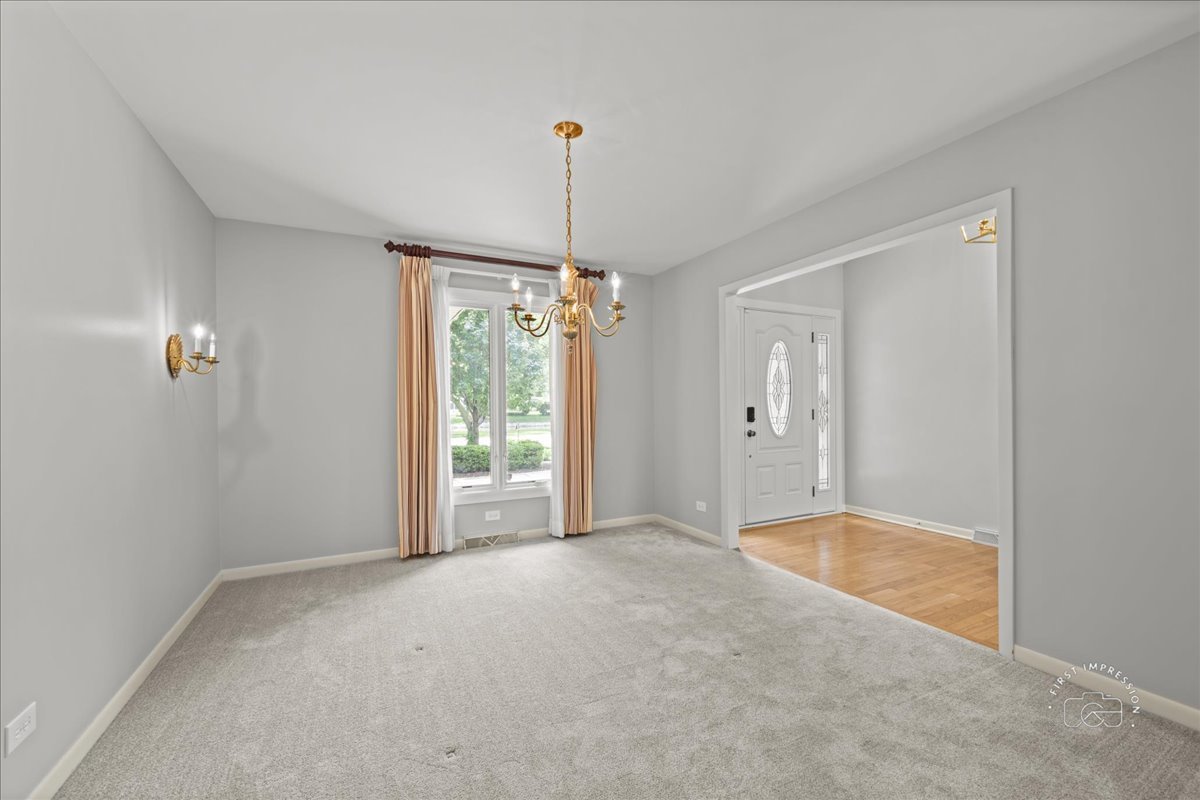 1105 West Bauer Road Naperville, IL 60563 - Photo 10 of 39 a view of an empty room with window and chandelier fan