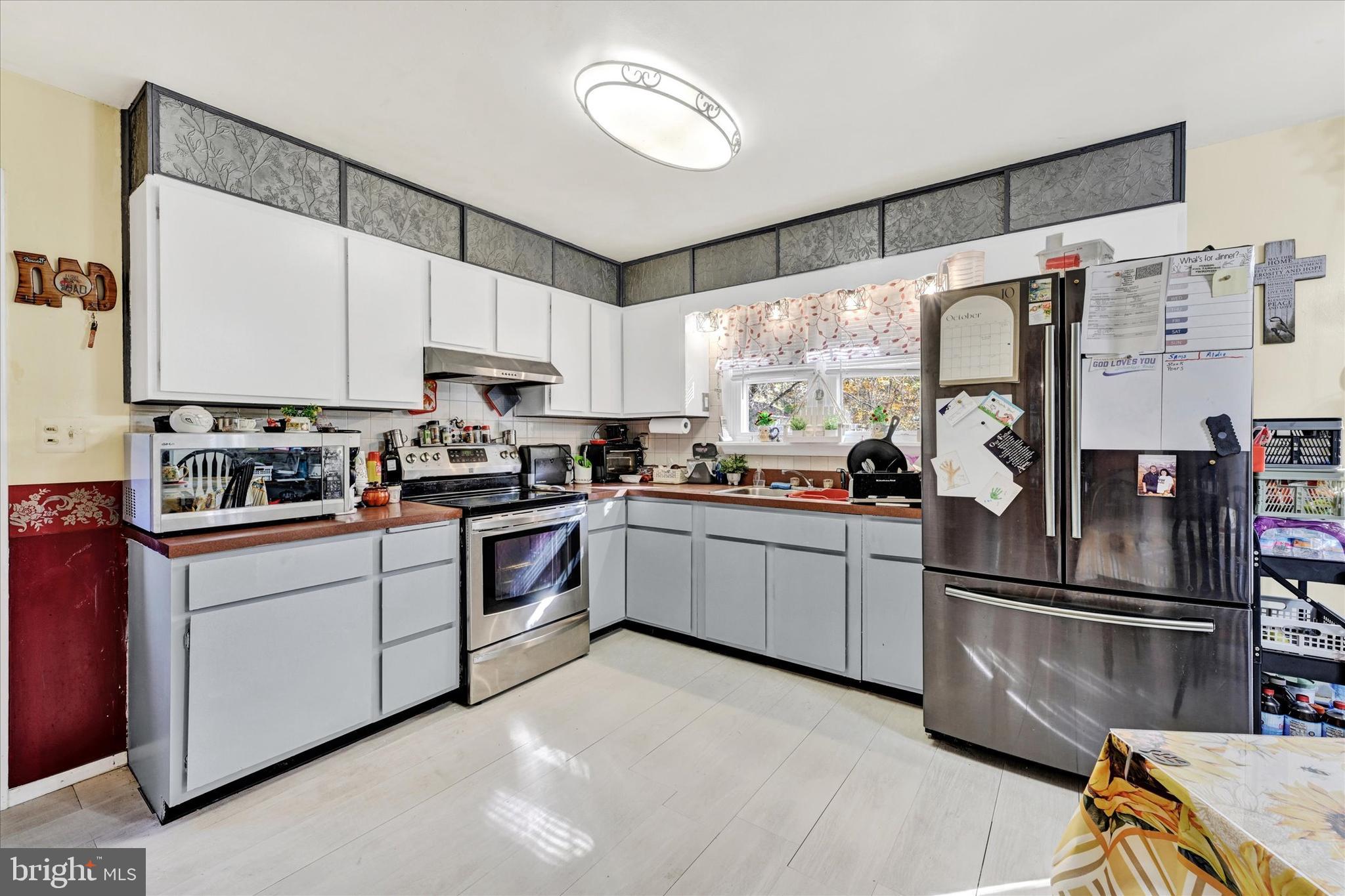 1321 Rustic Avenue Baltimore, MD 21237 - Photo 11 of 28 a kitchen with stainless steel appliances a refrigerator sink and cabinets
