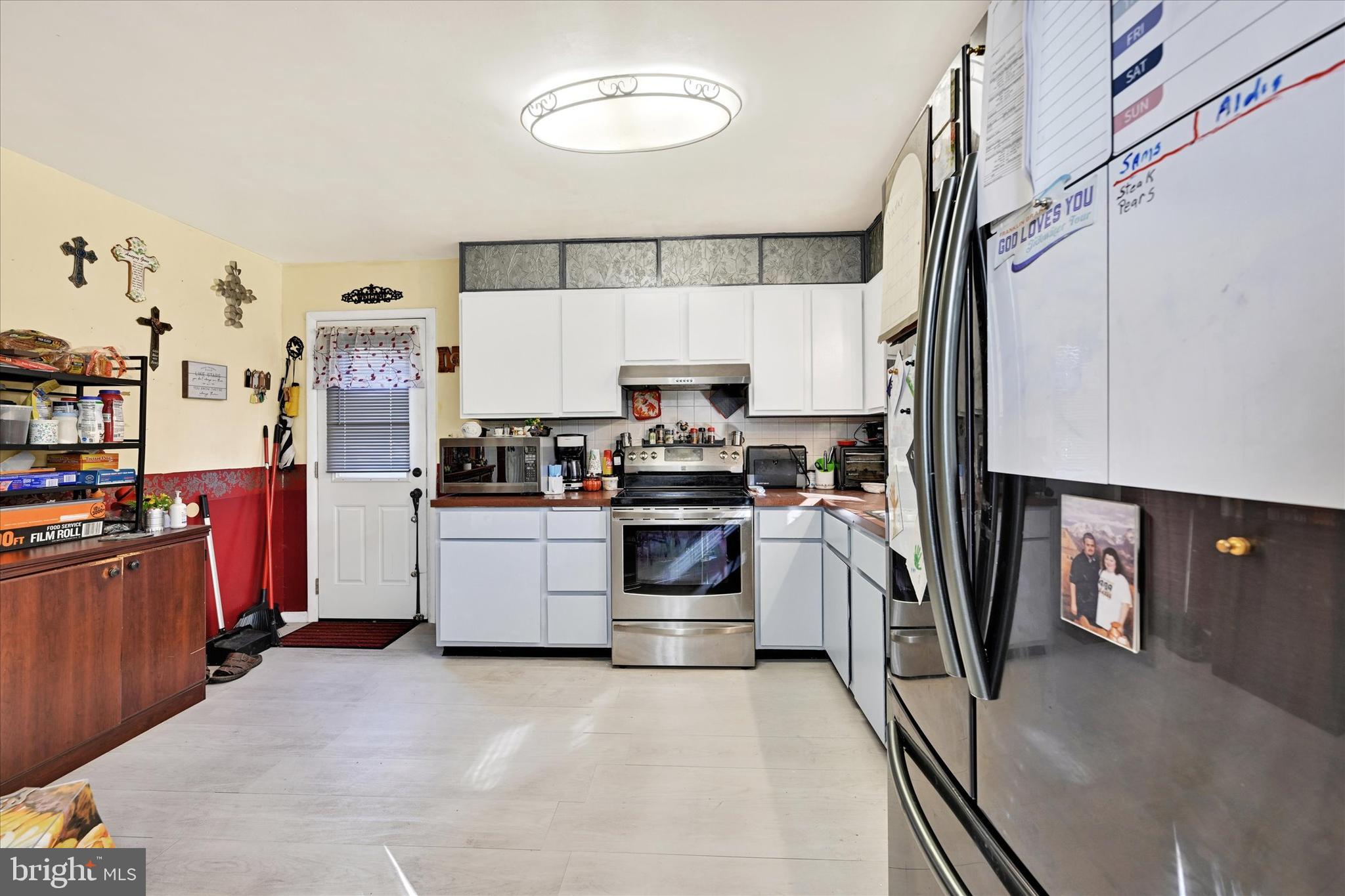 1321 Rustic Avenue Baltimore, MD 21237 - Photo 13 of 28 a kitchen with granite countertop a refrigerator and a stove top oven