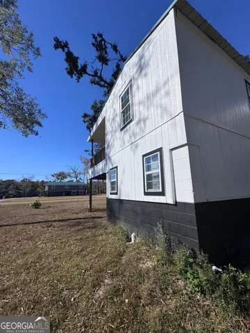 a view of a house with yard and a trees