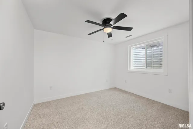 an empty room with chandelier fan