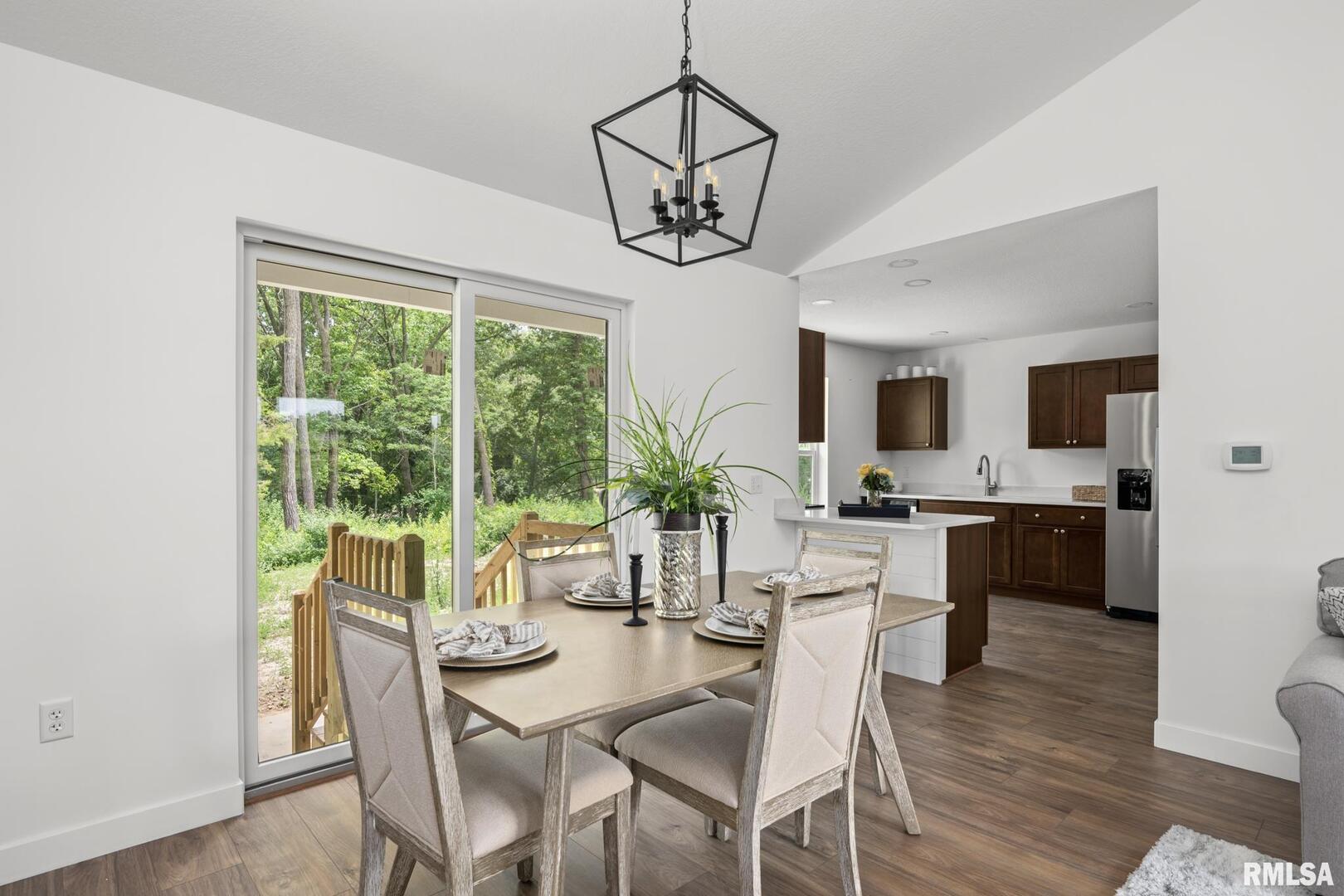 813 Williams Way Carbon Cliff, IL 61239 - Photo 7 of 36 a dining room with wooden floor a chandelier a wooden table and chairs