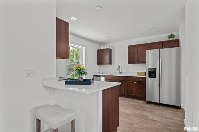 a kitchen with stainless steel appliances granite countertop a sink and a refrigerator