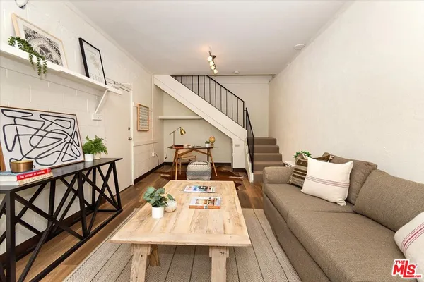 a living room with furniture and wooden floor