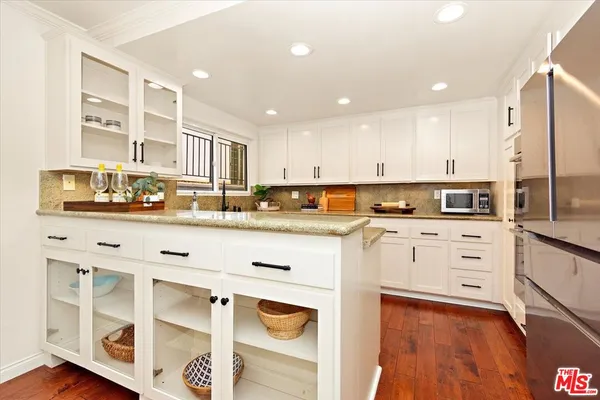 a kitchen with granite countertop white cabinets and stainless steel appliances