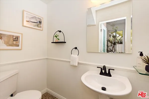 a bathroom with a toilet sink and mirror