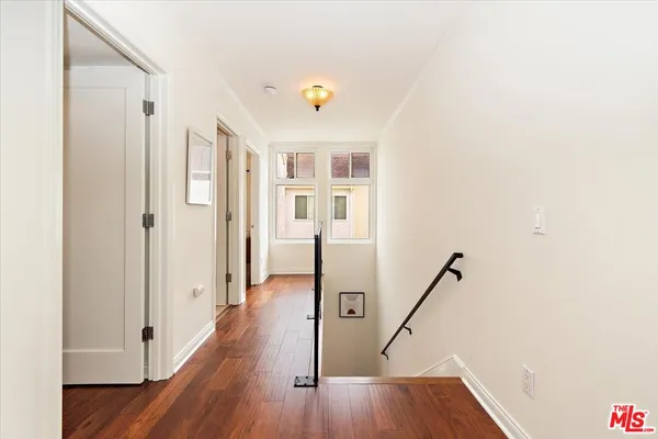 a view of a hallway with wooden floor and staircase