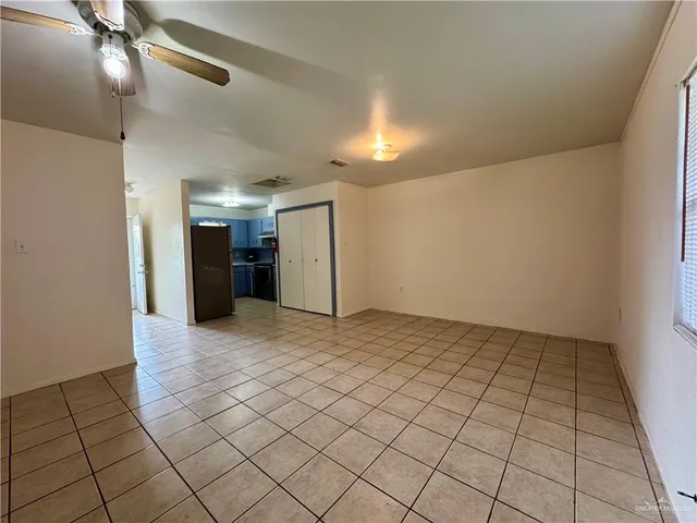 an empty room with windows and ceiling fan