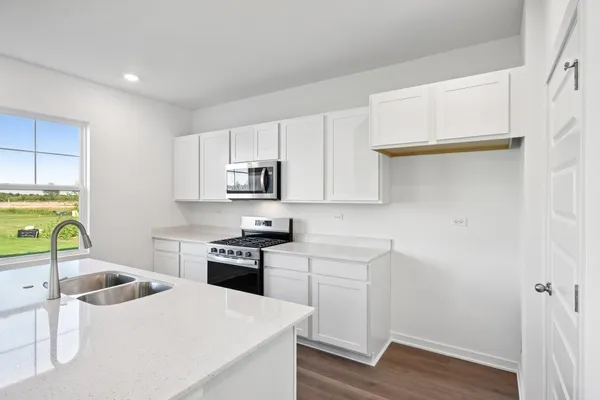 a kitchen with a sink a stove and cabinets