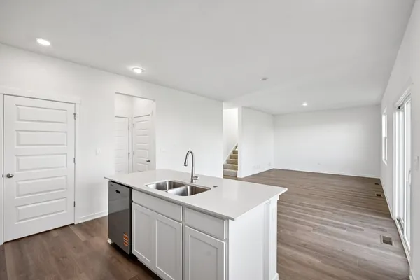 a kitchen with a sink cabinets and wooden floor