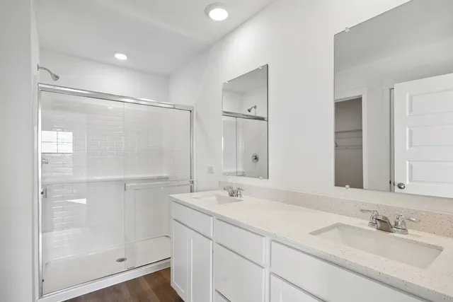 a bathroom with a shower sink vanity and mirror