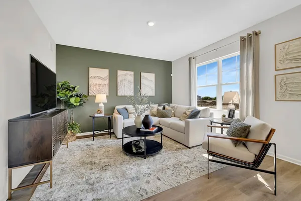 a living room with furniture a flat screen tv and a large window