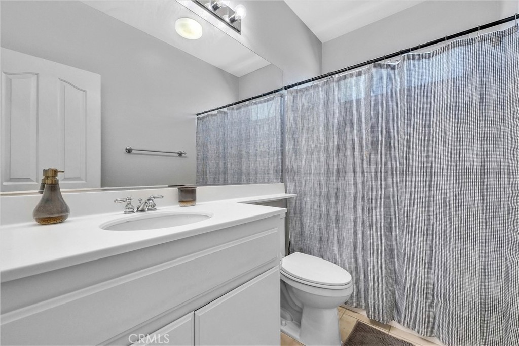 11499 Bridgeway Drive Riverside, CA 92505 - Photo 34 of 70 a bathroom with a sink a toilet and shower curtain