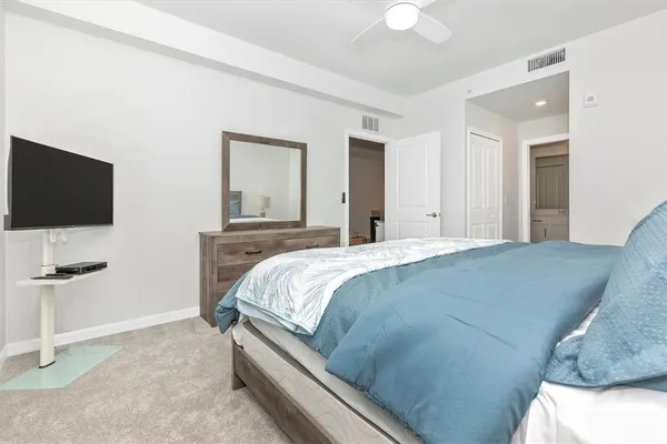 a bedroom with a bed and a dresser with mirror