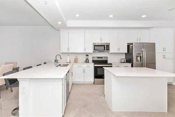 a kitchen with stainless steel appliances a stove a sink a microwave and cabinets