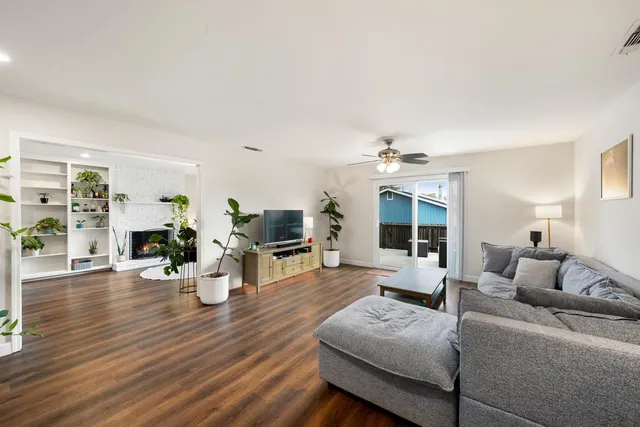 a living room with furniture fireplace and wooden floor