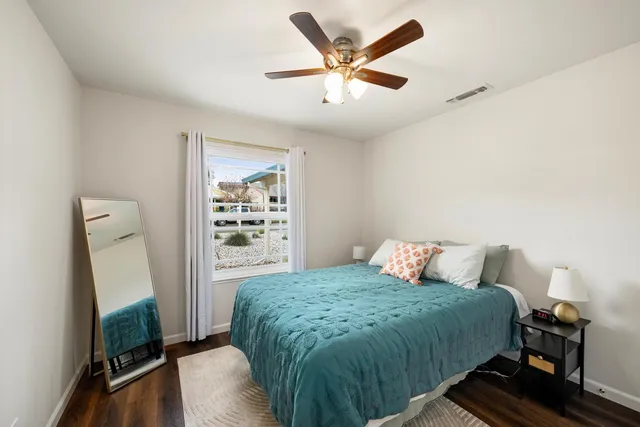 a bedroom with a bed and a flat tv screen on a dresser