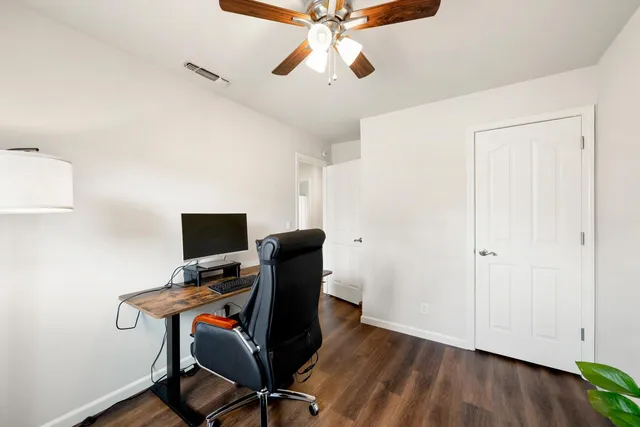 a view of a workspace with furniture and a ceiling fan