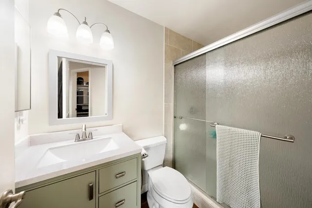 a bathroom with a granite countertop sink toilet and shower