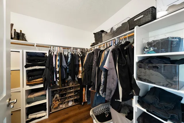 a view of walk in closet with clothes and shoes