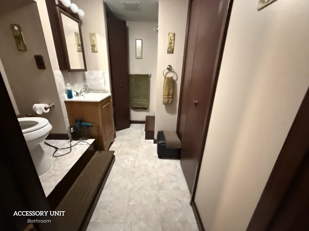 347 Ash Street Reading, MA 01867 - Photo 17 of 18 a bathroom with a sink a toilet a mirror and tub