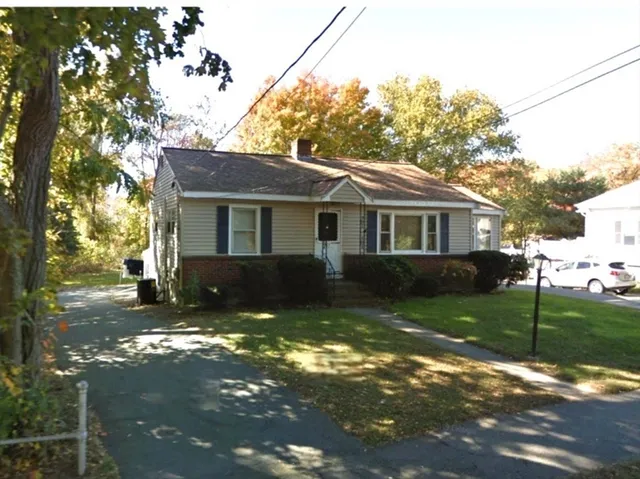 a view of a yard in front of a house with large tree