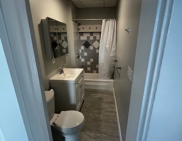 a white toilet sitting next to a bathroom sink and a shower
