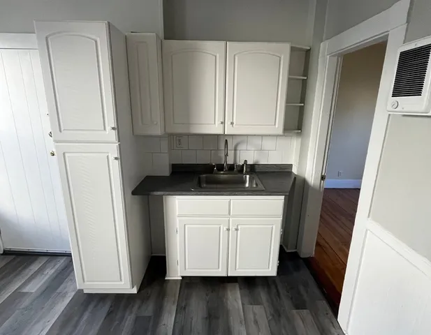 a utility room with wooden floor washer and dryer