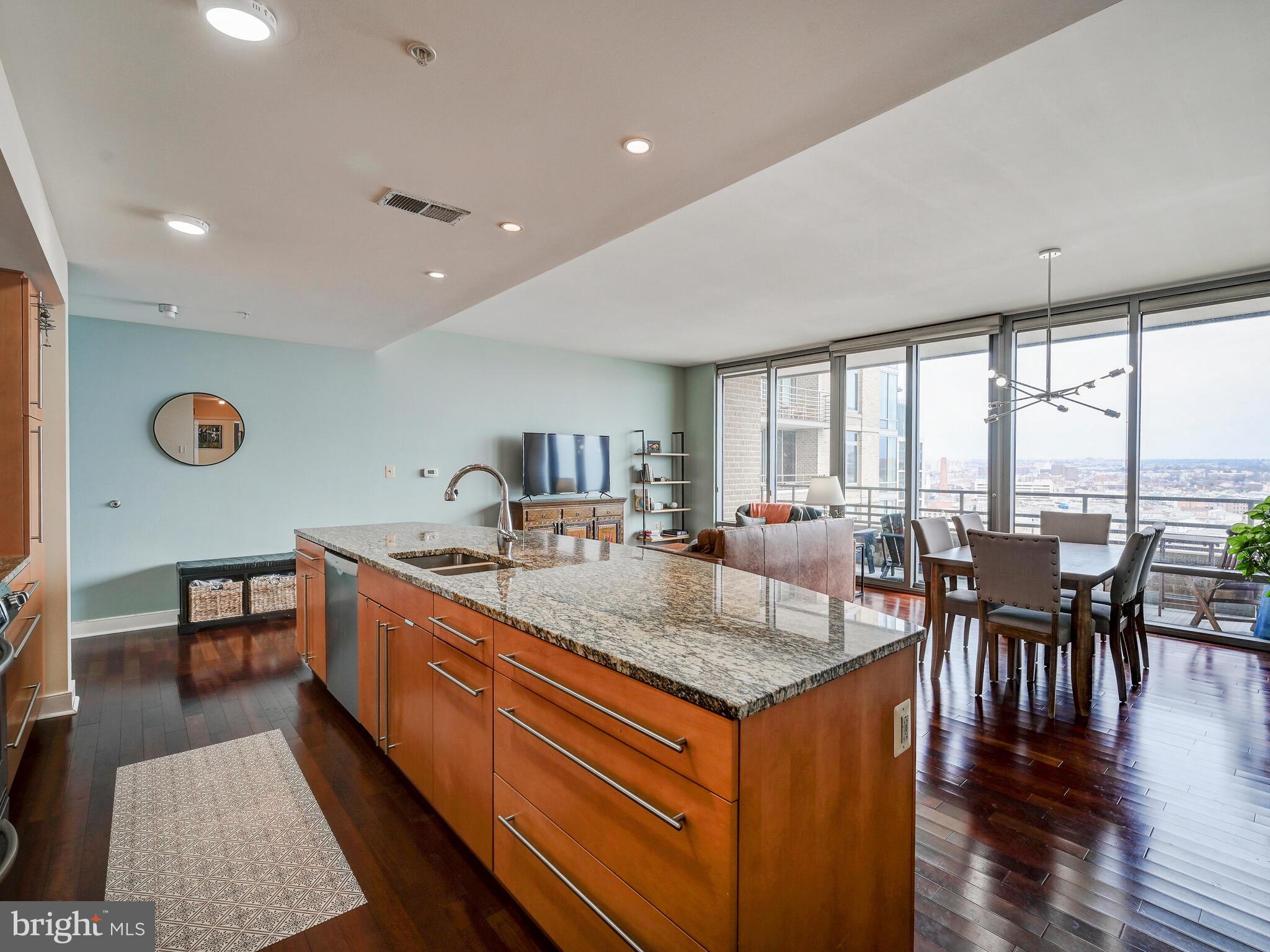 a dining hall with stainless steel appliances granite countertop a stove and a dining table
