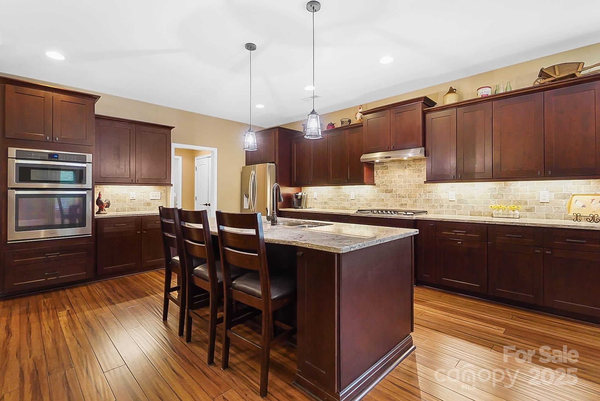 7305 Indian Trail Fairview Road Indian Trail, NC 28079 - Photo 5 of 48 a kitchen with a table chairs refrigerator and cabinets