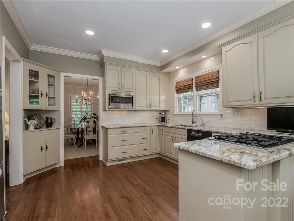 2701 Sharon Road Charlotte, NC 28211 - Photo 14 of 40 a kitchen with granite countertop a stove a sink and a refrigerator