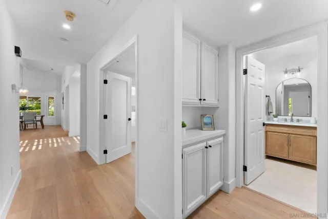 a view of a hallway with dining room and wooden floor