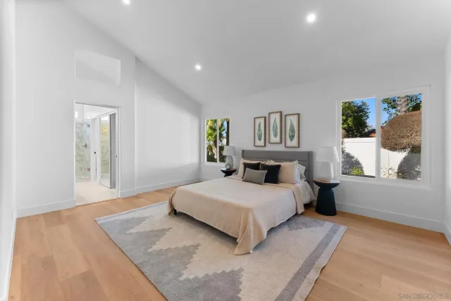 a bedroom with a large bed and a wooden floor