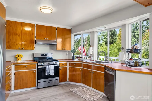 a kitchen with stainless steel appliances granite countertop a stove and a sink