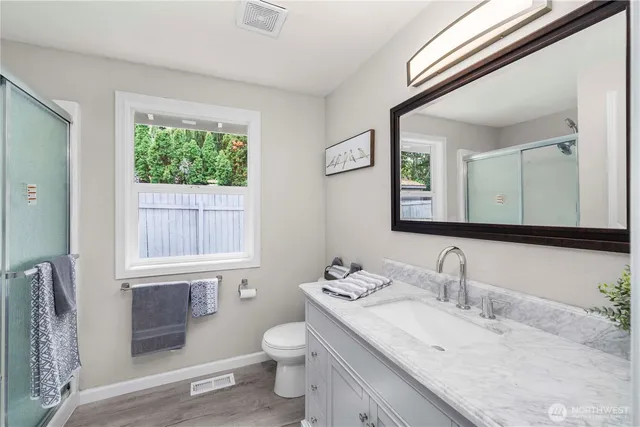 a bathroom with a granite countertop sink toilet and mirror