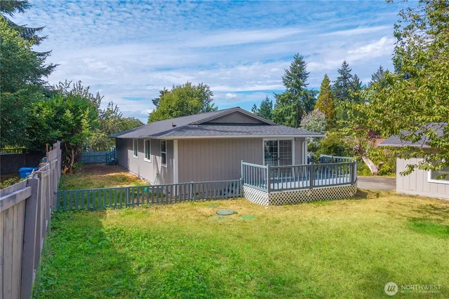 a view of a house with a yard and a large tree