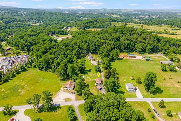an aerial view of residential houses with outdoor space and trees