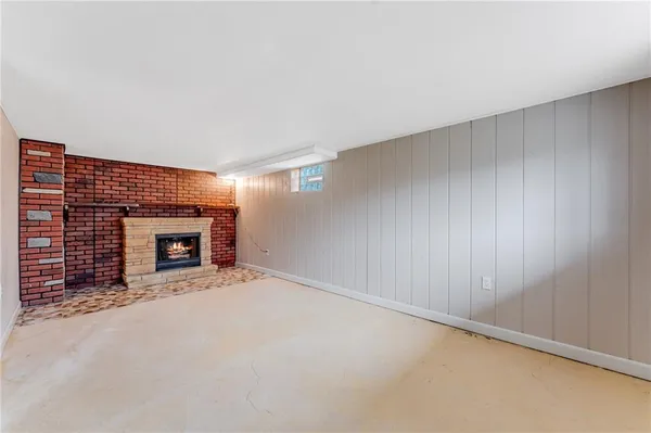 a view of an empty room with a fireplace and a window